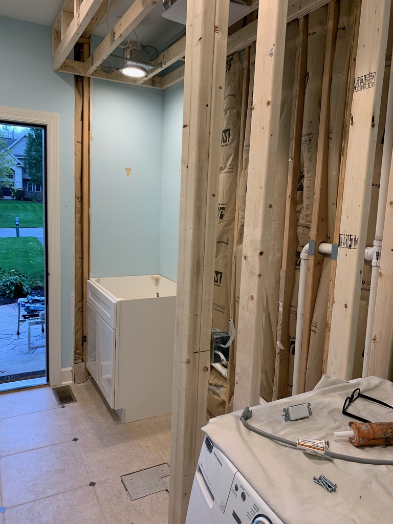 A laundry room with brand new studs being put up.