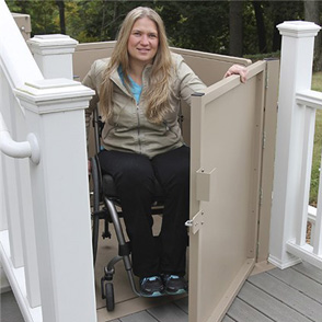 A woman exiting a wheelchair lift installed on her home's deck.