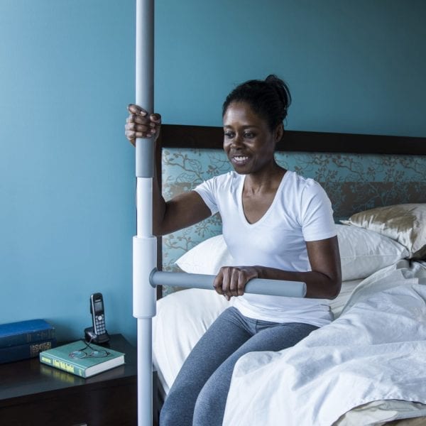 A woman using a stabilizing bar to rise from bed.